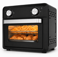 Black countertop air fryer oven with two silver control knobs, a glass door showing french fries and croissants inside, and ventilation slots on the side, photographed on a white background.